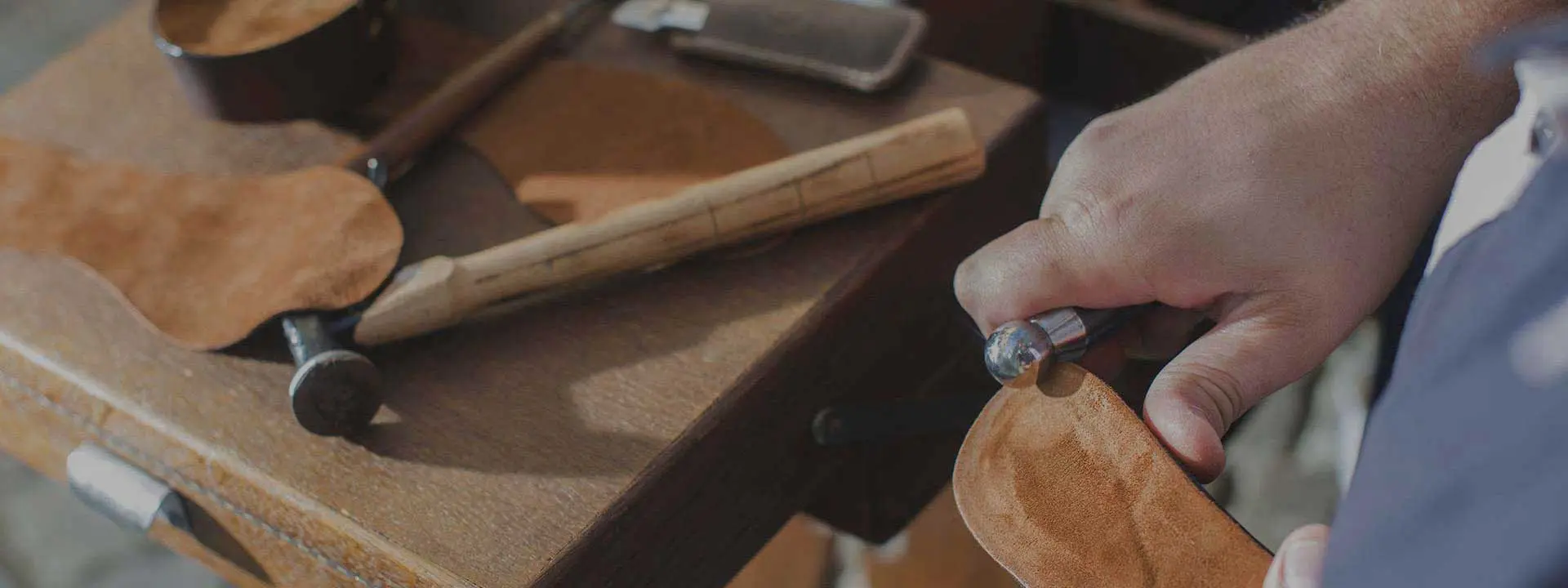 Artisan cordonnier réparant une paire de chaussures en cuir dans son atelier de quartier